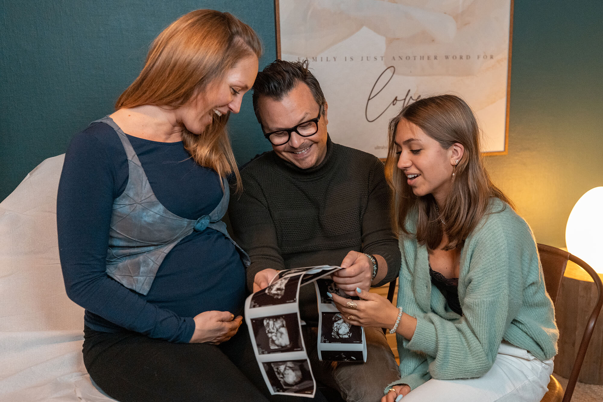Mand, kvinde og teenage datter ser billeder fra en ultralydsscanning